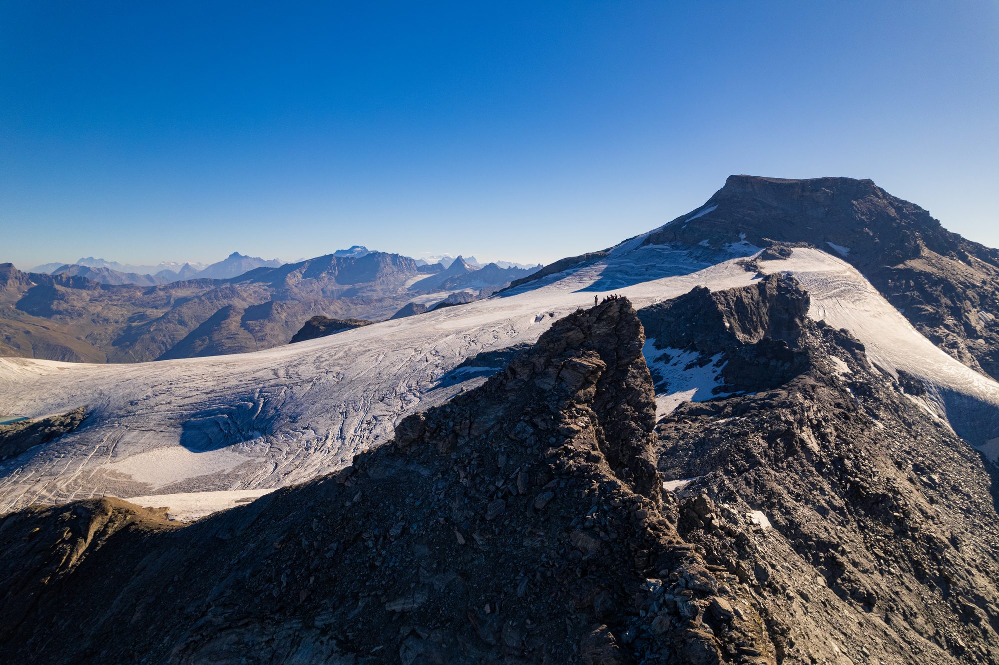 Cordée en crête rocheuse, panorama de sommets enneigés