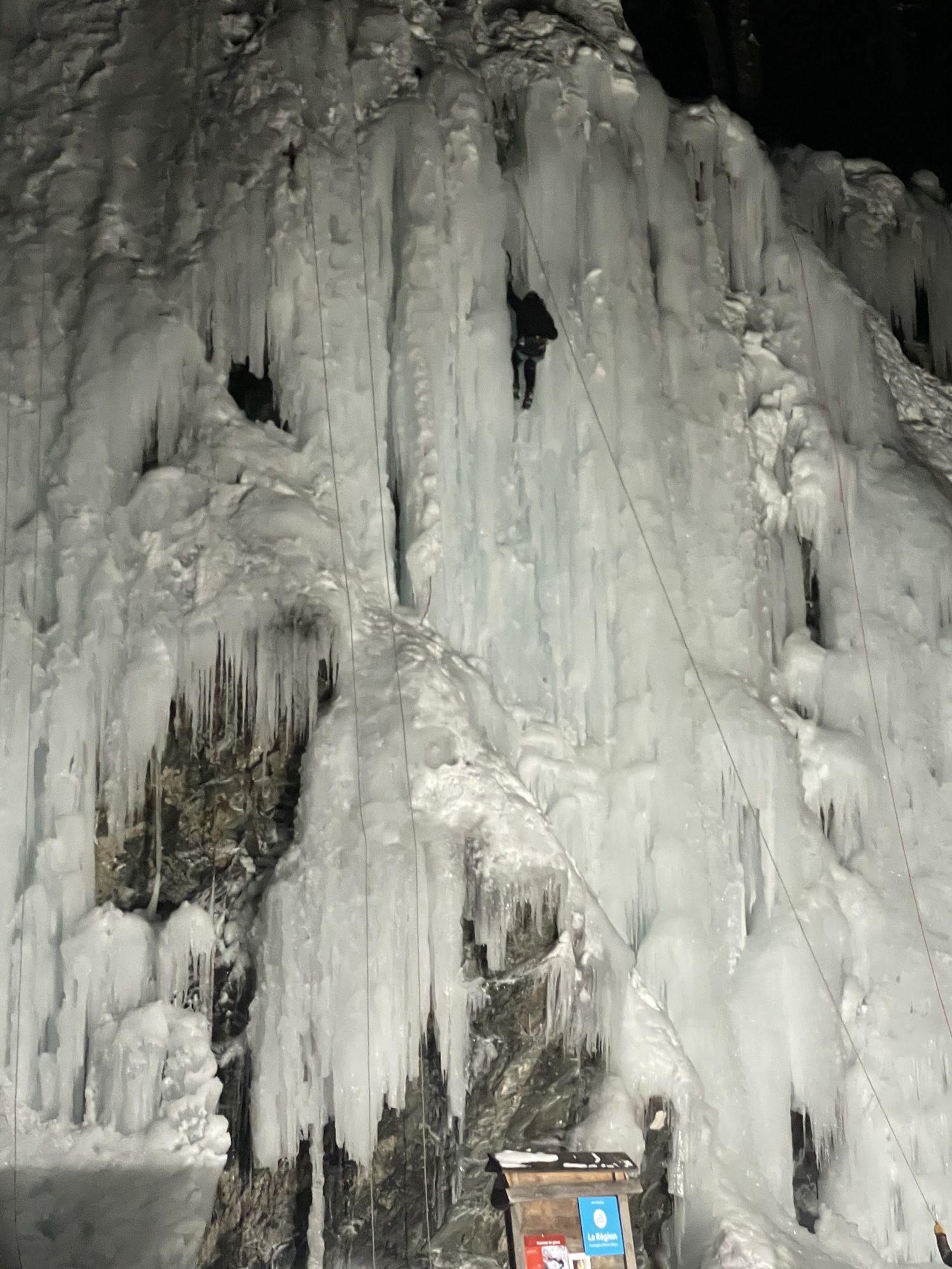 Grimpeurs minuscules sur la grande cascade illuminée de nuit