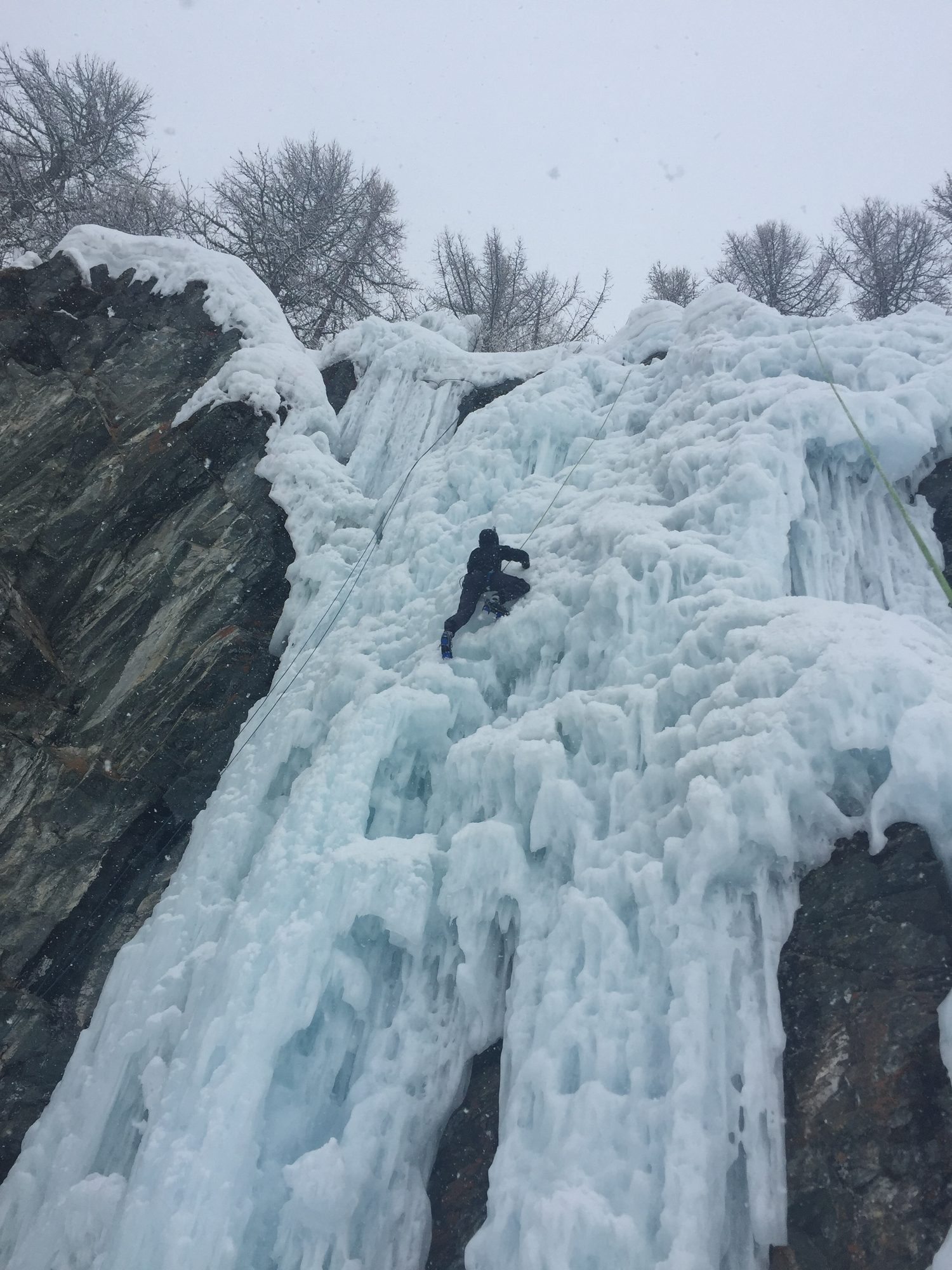 Grimpeur sur la cascade sous la neige