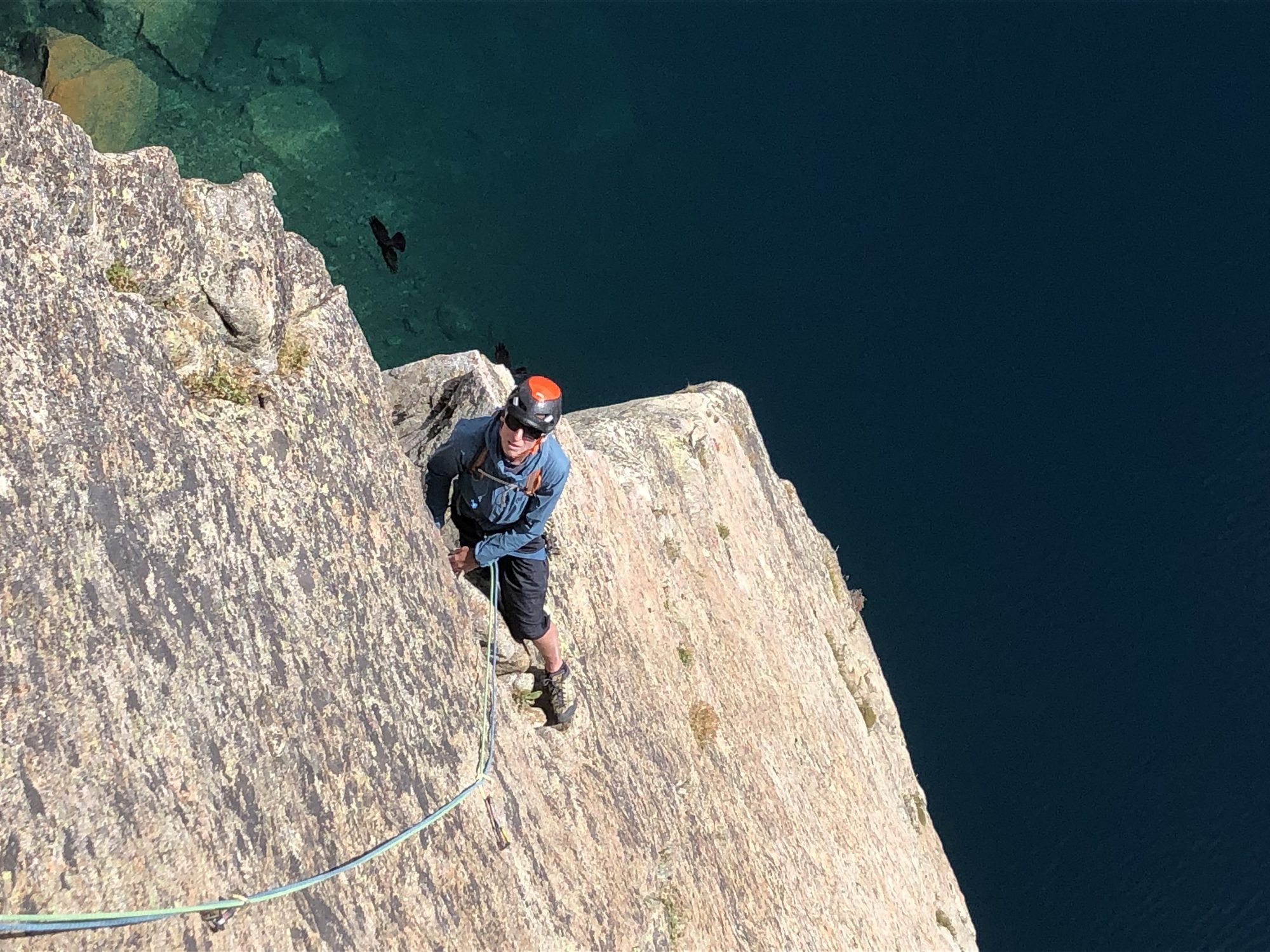 Grimpeur en second au-dessus d'un lac d'altitude profond