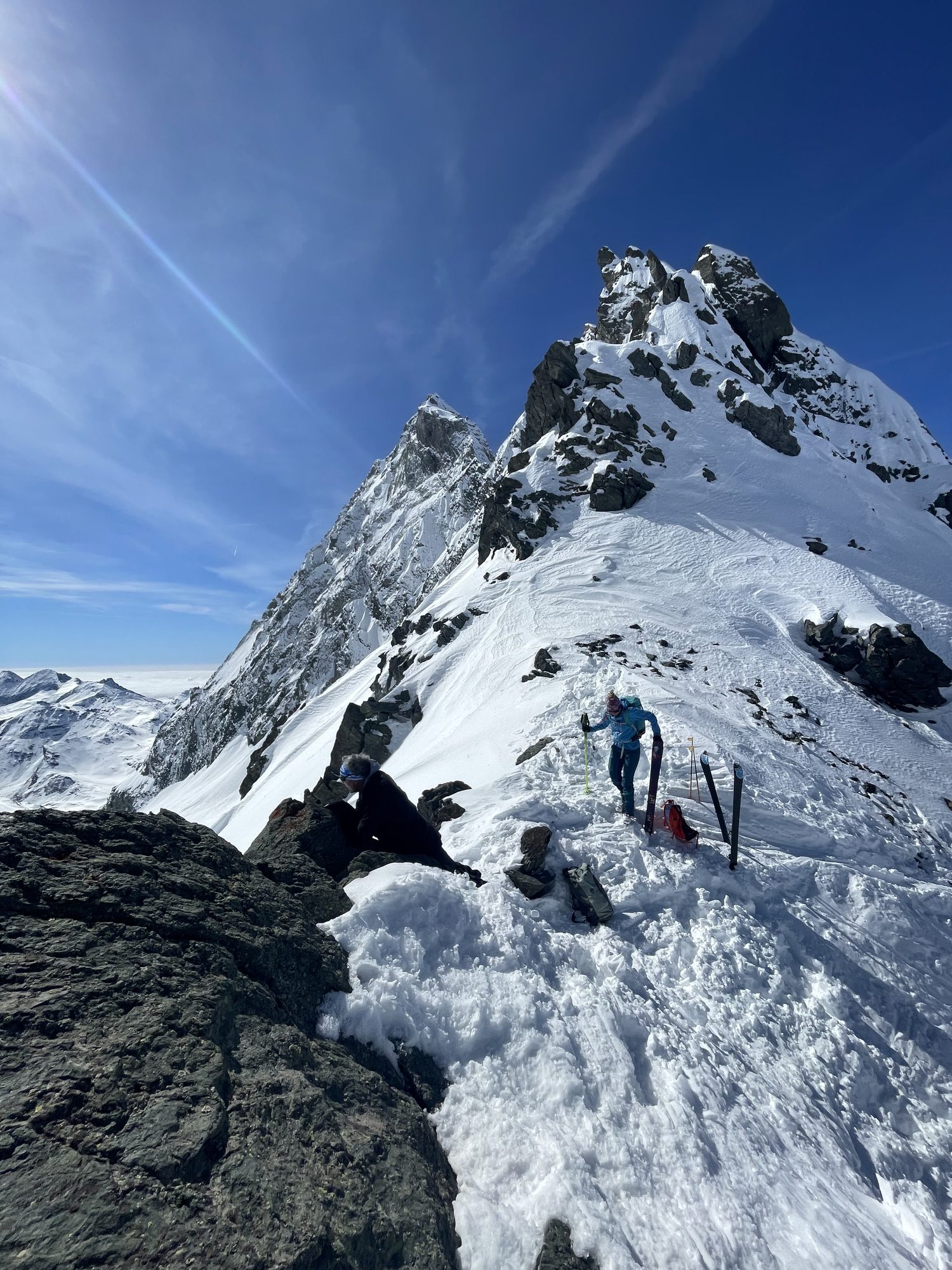 Randonneurs sur une crête rocheuse, mer de nuages en contrebas