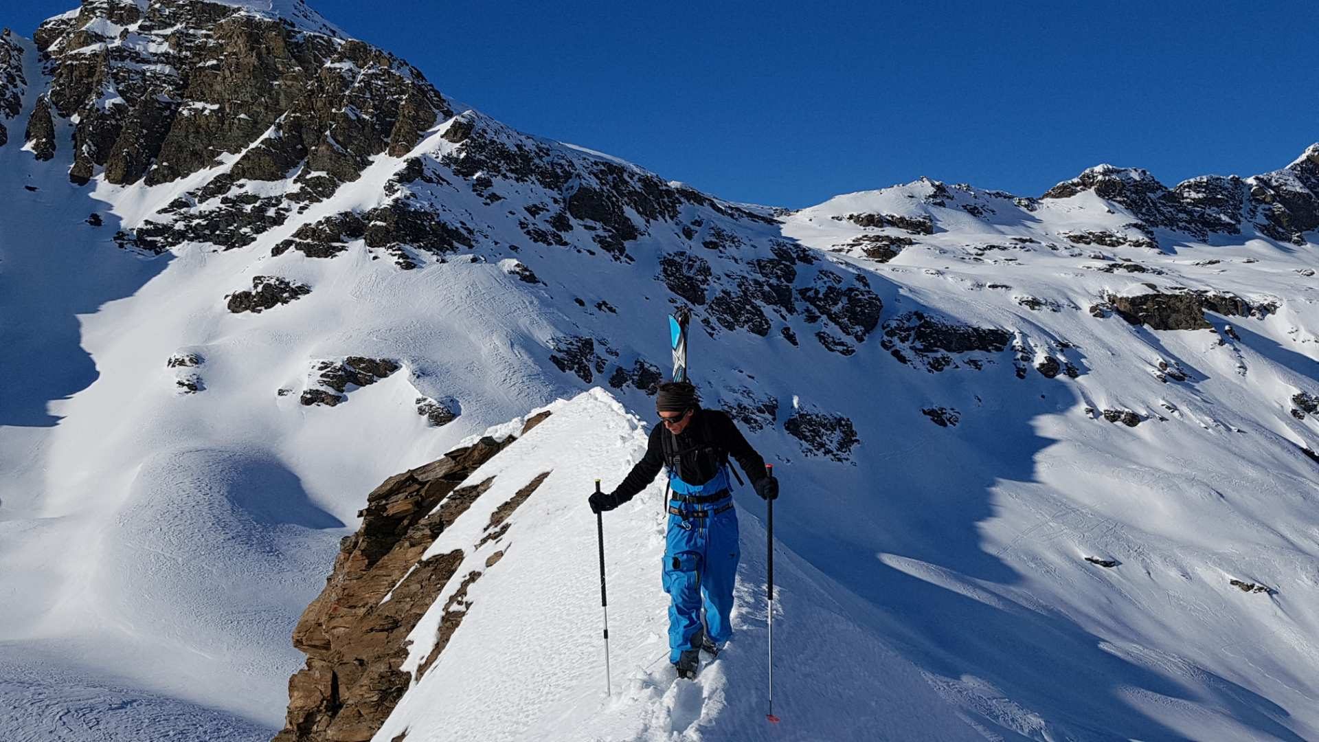 Skieur avançant sur une arête entre les sommets