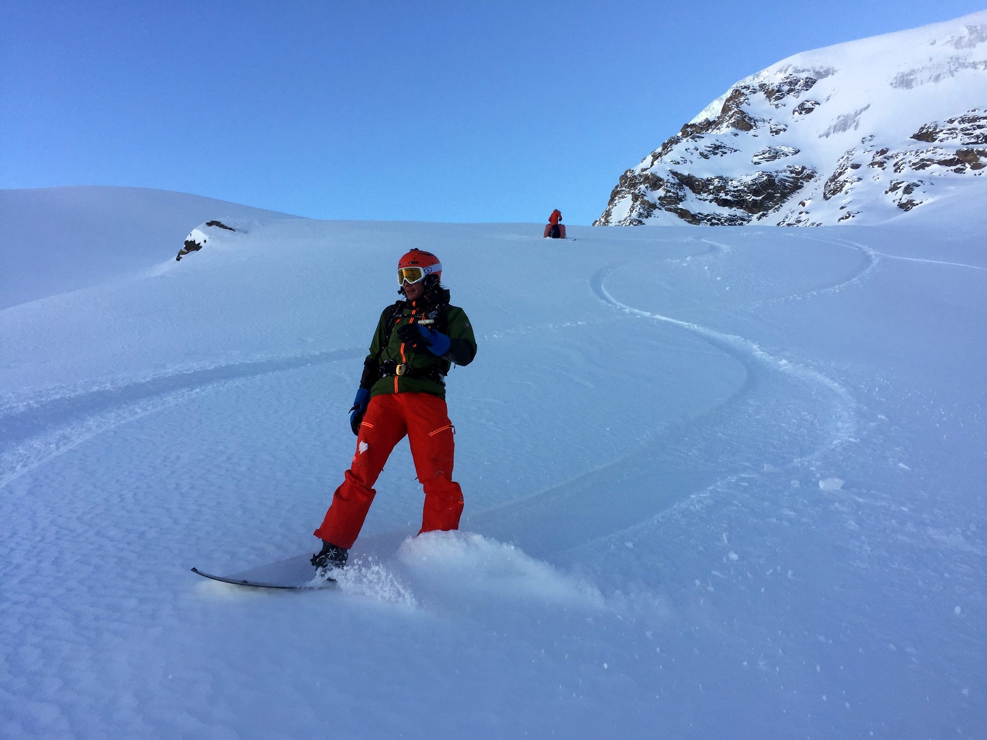 Skieuse en pleine conversion dans la poudreuse, ciel bleu