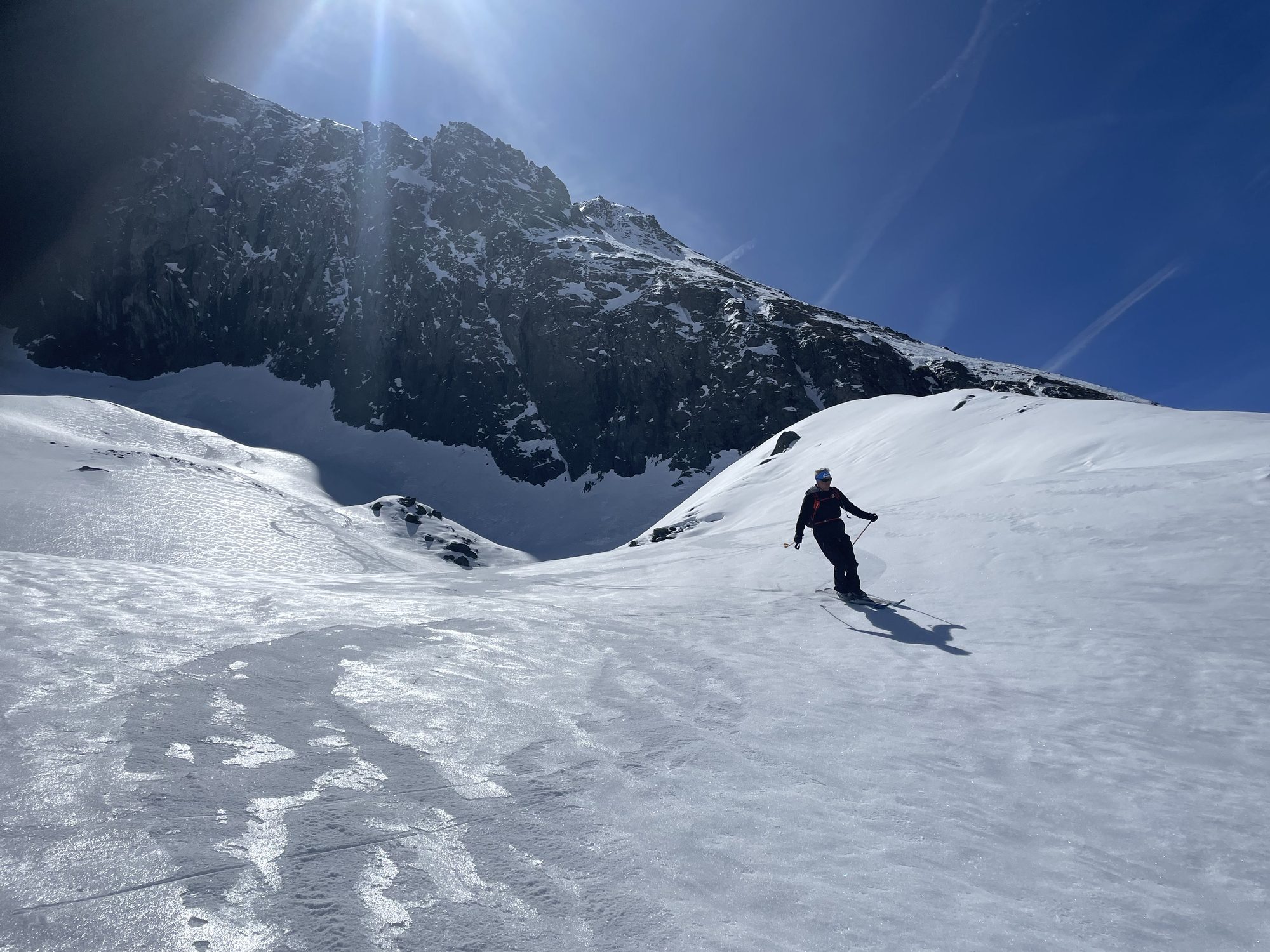 Skieur descendant face à un sommet, contre-jour